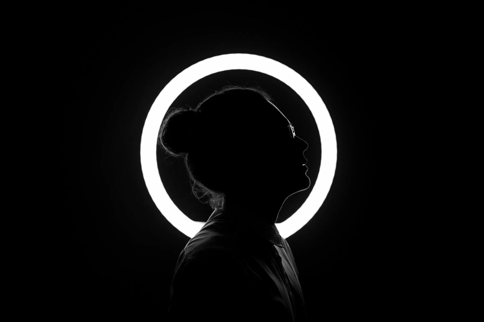 Figura in controluce di profilo, come sfondo una ring light