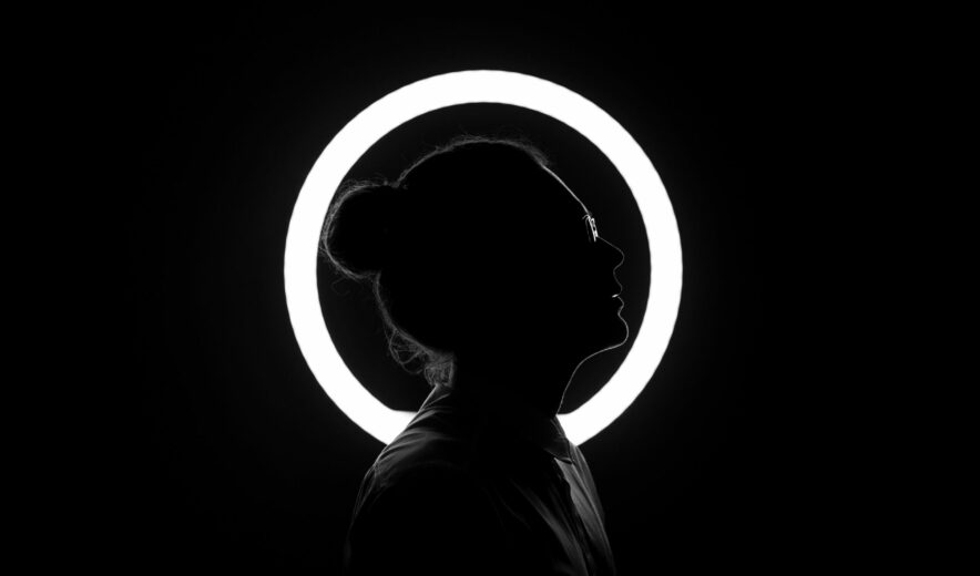 Figura in controluce di profilo, come sfondo una ring light